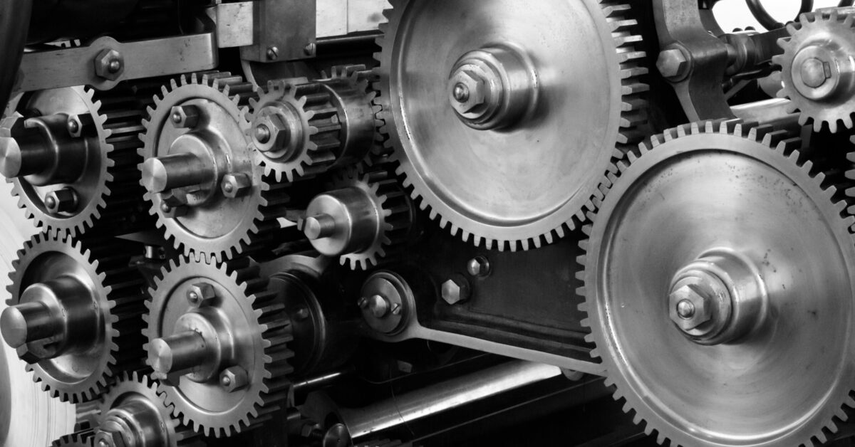 Close-up view of a complex industrial gear mechanism in black and white.